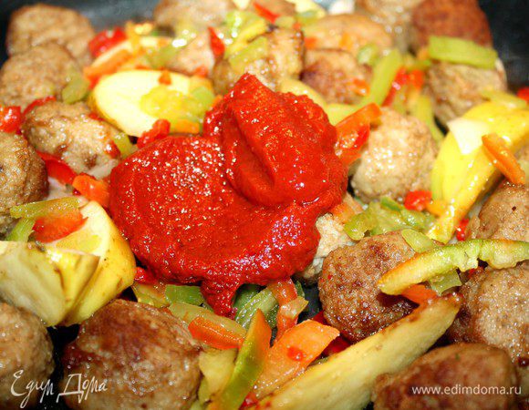 Вторую половину луковицы нарезать вдоль на полукольца и добавить в сковороду к тефтелям.Туда же добавить мелко порезанный сладкий  и острый перец.Тушить минут 5.Затем добавить протёртые томаты,нарезанную кинзу и бульон.Посолить,поставить в духовку,нагретую до 180*С,и тушить до готовности.Приятного аппетита!