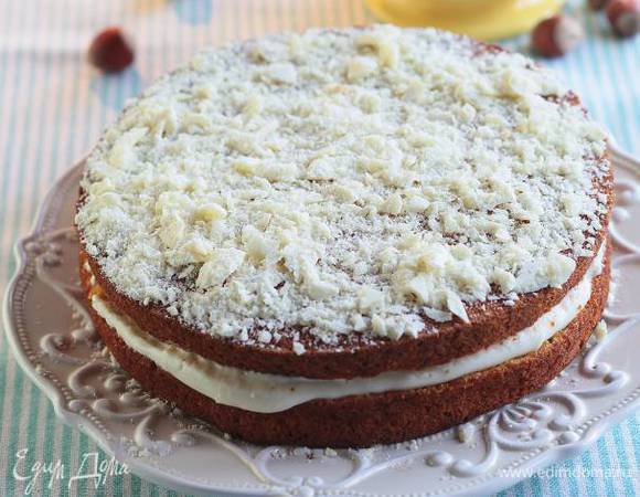 Остывший корж разрезать по толщине пополам, промазать большей частью сметанного крема и снова соединить. Сверху тоже смазать кремом и украсить натертым белым шоколадом.