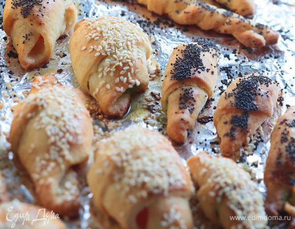 Одну половину теста раскатать в тонкий пласт, нарезать его треугольниками и скрутить в рогалики, положив внутрь каждого по пол чайной ложки джема. 