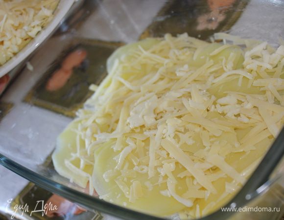 Керамическую или другую удобную форму (жаропрочную) смазать кусочком сливочного масла. Первый слой будет тертый сыр. Второй слой - картофель. Третьим слоем выкладываем лук с чесноком. Снова картофель. Сверху посыпать сыром и залить сметанным соусом. 