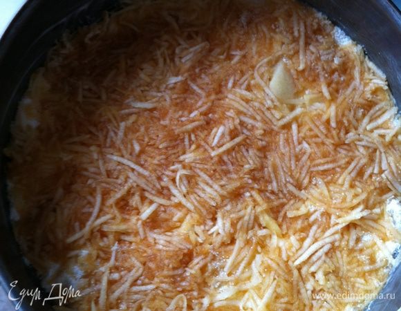 3. На дно формы высыпьте первый стакан сухой смеси, а сверху выложите половинку натертых яблок.