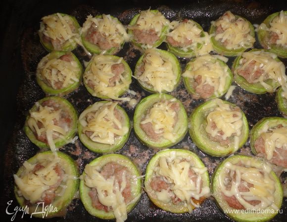 За 5 минут до готовности вынуть противень из духовки и посыпать кабачки тертым сыром.