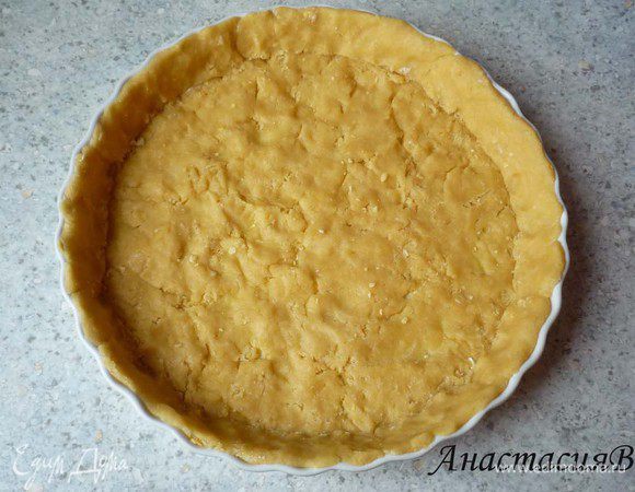 Форму для киша или разъемную форму (28см) смазать маслом. Выложить тесто, распределить по дну, сформировать бортики.