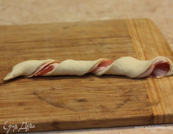 Скрутите аккуратно тесто с беконом, как показано на фотографии.