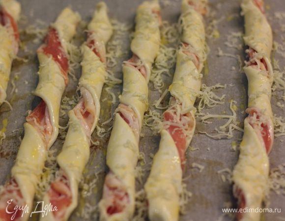 Смажьте язычки желтком. Натрите сыр на мелкой терке и посыпьте сверху на каждый язычок.