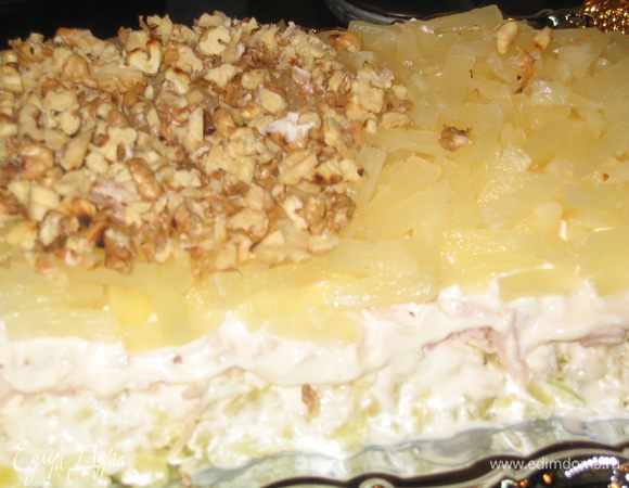 Слой 3: нарезать кольца ананаса и аккуратно их выложить, сверху посыпать орехами и смазать майонезом верх и бока