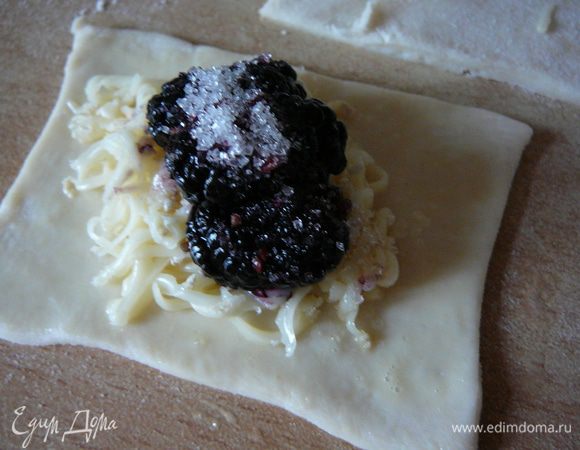 Затем очередь тертого "Бри", слегка вдавливаем его с тесто, ягода и немного сахара.
