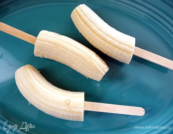 Берем банан и режем его на 2-3 части. И одеваем на эти части деревянные плочки.