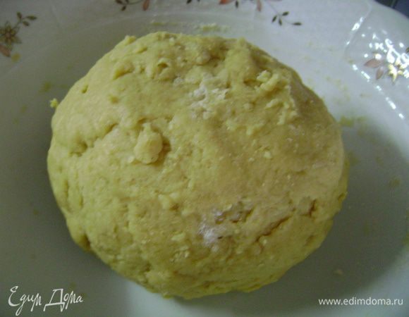 Положить творог в миску и постепенно примешивать к нему сахар, ванильный сахар, соль, оливковое масло, молоко и желтки. Перемешать оба вида муки с разрыхлителем, затем примерно половину примешать деревянной ложкой к желтковой массе. Добавить оставшуюся муку и быстро вымесить тесто. 