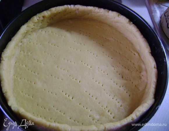 Тесто накрыть целлофаном и положить в холодильник на 20 мин. Предварительно нагреть духовку до 200 гр. Раскатать тесто на посыпанной мукой рабочей поверхности в пласт толщиной 5 мм.
Форму смазать маслом и выложить в неё тесто. Тесто плотно прижать к дну и стенкам формы и много раз наколоть вилкой. Накрыть тесто пергаментной бумагой. На бумагу выложить горох или фасоль. Выпекать корж без начинки около 12 мин. 