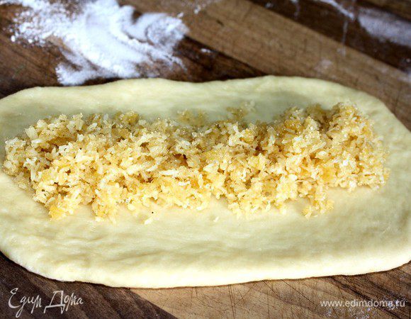 Поднявшееся тесто обмять и разделить на 12 кусков.Каждый кусок раскатать в длинный овал,распределить начинку,завернуть узкие края на 1-2 см к центру и свернуть лепёшки в рулеты по длинному краю.