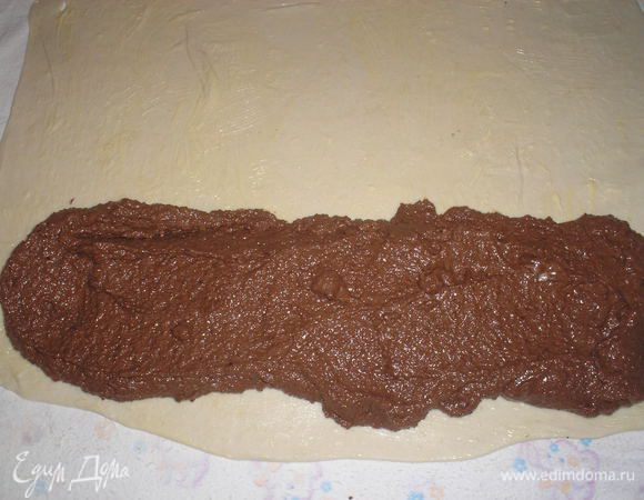 Растопить 30 гр сливочного масла. Половину нанести на тесто. С одного края штруделя выложить начинку.