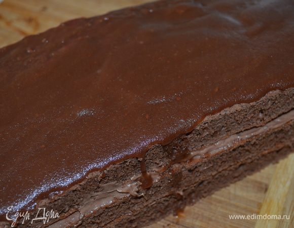 На верхний корж наносим глазурь по-немногу и разравниваем. Она практически сразу начинает твердеть. Сразу, пока глазурь не схватилась нарзеть на кусочки-пироженки. 