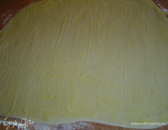 Затем раскатываем тесто толщиной 1-2 мм, смазываем его поверхность растопленным сливочным маслом,