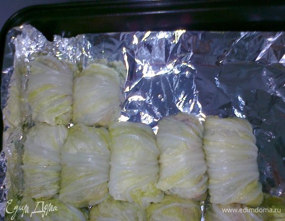 5. Выстилаем глубокий противень фольгой так, чтобы ее хватило еще и на то, чтобы потом накрыть голубцы. Выкладываем плотными рядками голубчики. Накрываем фольгой. Ставим противень в разогретую до 180 градусов духовку на 30 минут.