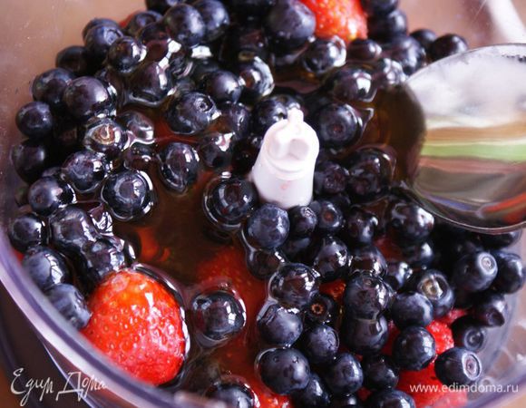 Чернику вымыть. Клубнику вымыть и удалить плодоножку. Выложить ягоды в чашу блендера. Добавить мед.