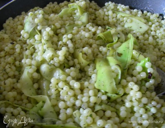 Оставшееся зеленое масло разогреваем на сковороде, выкладываем наши ленты цуккини и готовим несколько минут. Затем добавляем кускус, все перемешиваем и прогреваем несколько минут. 
