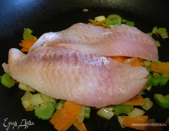 В сковороде разогреваем сливочное масло и обжариваем наши овощи минут 5. Затем выкладываем на них рыбку.
