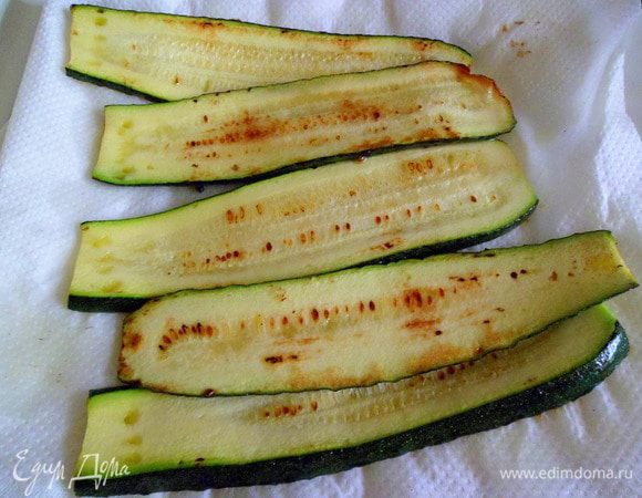 Цукини нарезать тонкими ломтиками одинаковой толщины, смазать их маслом и обжарить с двух сторон на обычной сковороде(но не сильно), затем откинуть на салфетку