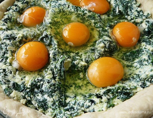 Выложить 1 пластину теста в смазанную маслом форму и сделать вилкой наколы по поверхности, чтобы тесто не пузырилось. Тесто должно слегка свисать по краям... Выложить начинку, сделать 6 углублений и вылить яйца.
