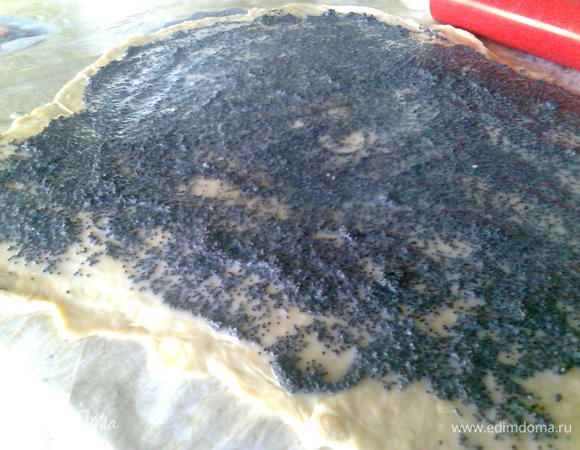 Раскатываем тесто в прямоугольный пласт размером 25 на 35 см. Равномерно распределяем начинку и скручиваем в рулет.