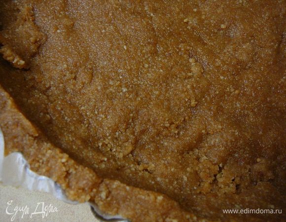 Сливочное масло растопить и влить в крошки,тщательно перемешать до образования однородной массы похожей на тесто.Заполнить форму(23см)тестом,утрамбовав его и так же сделать бортики.