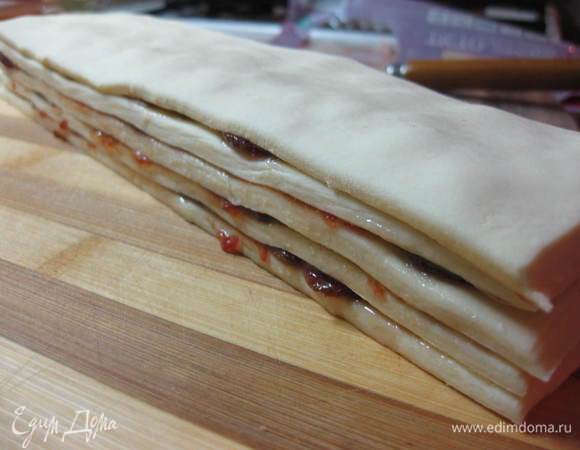 Сложить полоски с джемом стопочкой, сверху выложить чистую полоску теста и слегка придавить.