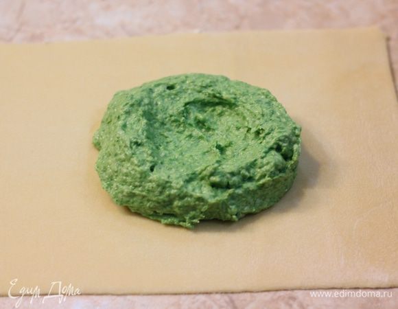 Положите полторы столовых ложки начинки, сформировав из нее шар. Прижмите шар (я это делал той же ложкой) и сделайте посередине углубление. Для второго равиоли начинку положите тесто на расстоянии 3-4 сантиметров от первого шарика начинки.