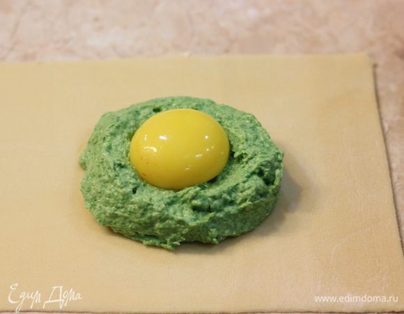 Аккуратно выложите по желтку в углубление начинки для каждого равиоли (я делал одновременно два). Смажьте холодной водой тесто вокруг начинки. Для этого лучше всего воспользоваться кисточкой.