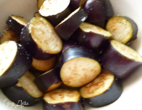 Баклажаны помыть, удалить хвостики и нарезать поперек не очень тонко. Немного посолить, перемешать, закрыть крышкой и отставить в сторону.