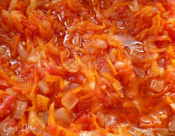 Теперь приготовим овощную заправку: морковь и помидоры натереть на крупной терке, лук нарезать мелким кубиком, у горького перца удалить семена и мелко его нарезать. Нагреваем на небольшом огне сковороду, наливаем растительное масло и сначала слегка обжарим лук 2-3 минуты, затем добавим морковь, горький перец и помешивая обжариваем пока лук станет желтого цвета от сока моркови, добавляем помидоры, перемешать и тушить, пока испарится половина жидкости. Добавить измельченный чеснок, слегка посолить, выключить огонь и дать немного настояться.