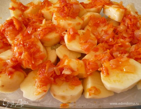 Картофель почистить и нарезать поперек или дольками. Выкладываем слой картофеля в форму для запекания (я запекаю в стеклянной), покрываем половиной овощной заправки.