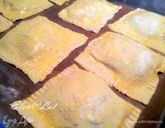 Пирожки выложить на противень, смазать яйцом и посыпать кунжутом. 