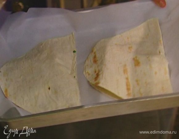 Противень выстелить бумагой для выпечки и положить на него лаваш с начинкой. 