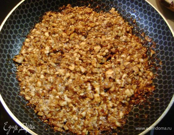 На сковороду высыпать сахар и на среднем огне сварить легкую карамель, добавить сливочное масло. Как только масло растопится, всыпать орехи, перемешать и через 2 мин. выключить. 