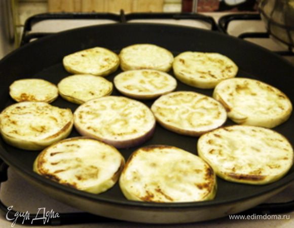 Пока запекается перец, нарезать баклажаны на кружки по 0,5 см и обжарить их или на гриле или на сковороде с антипригарным покрытием, смазав оливковым маслом с обеих сторон.
