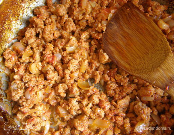 Лук обжарьте на сковороде, добавьте фарш, посолите, поперчите, введите томатную пасту.