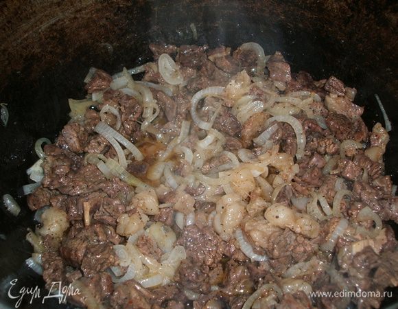Лук нарежьте полукольцами и, когда мясо обжарится, добавьте лук и опять под крышку — тушить.