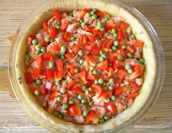 Затем выложить на тесто филе лосося, горошек и нарезанный перец, посолить, поперчить.