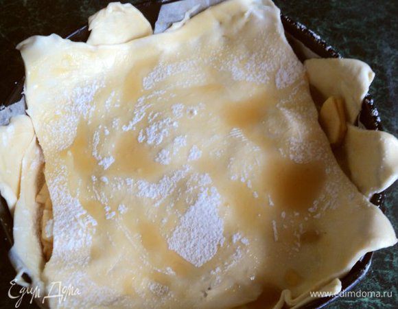 Дно формы застелить бумагой для выпечки, смазать маслом. Выложить три пласта теста, поливая каждый коньяком и посыпая сахарной пудрой. Листы теста выкладывать так, чтобы углы теста образовывали бортик.