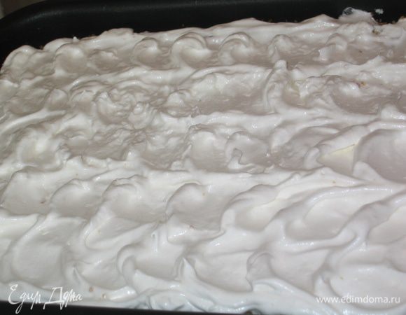 Выложить белковый крем поверх пирога и нанести ложкой произвольный рельеф или рисунок