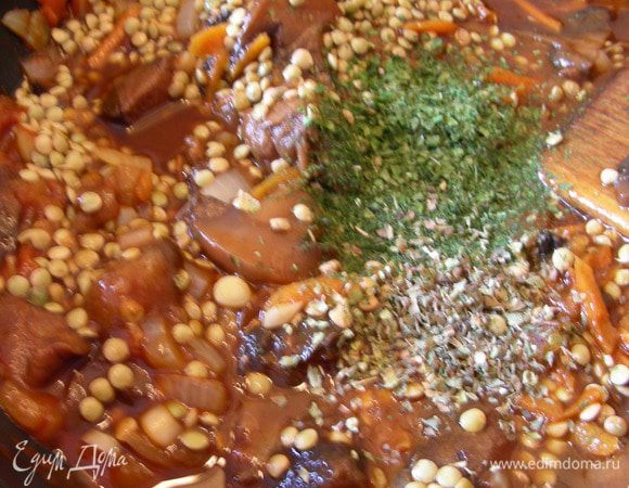 Добавляем чечевицу. Заливаем все горячей водой, чтобы немного покрывала смесь. Солим, перчим, добавляем травки. Готовим минут 40 до полного впитывания жидкости. Затем можно дать блюду настояться минут 15-20.
