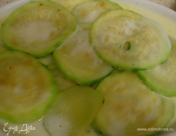 Форму для запекания смазать сливочным маслом, выложить обжаренные кабачки и залить все соусом. Посыпать тертым сыром.