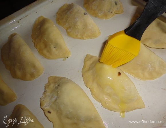 Смазать пирожки слегка взбитым яйцом.
