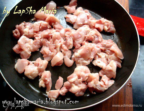 Куриные бедра или филе нарезаем на небольшие кубики и выкладываем в сковороду, в которой жарились грибы. Добавляем ещё немного масла и обжариваем мясо до румяной корочки.