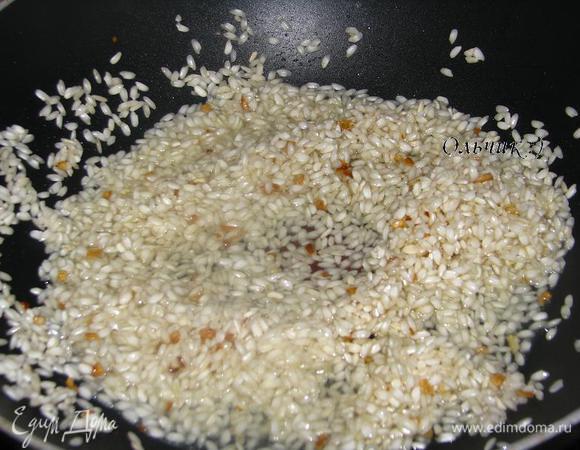 Добавляем рис, прогреваем его в течении трех минут, не забываем помешивать. Затем добавляем вино, даем ему выпарится.
