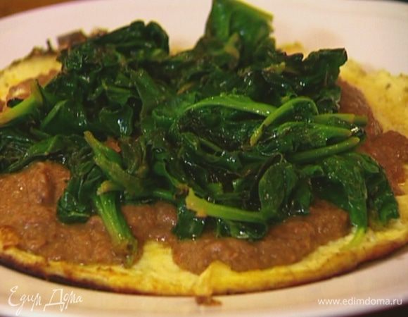 Выложить омлет на блюдо, сверху поместить фасолевую начинку и шпинат, присыпать все оставшимся тмином.