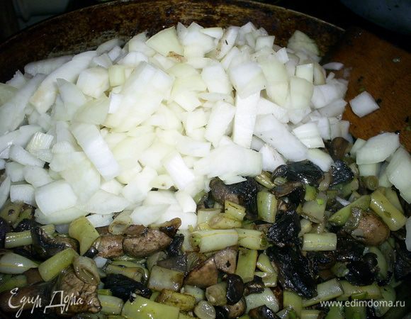 Следим, чтобы наше блюдо не подгорело. Как только жидкость полностью испарится, добавляем на сковороду растительное масло и мелко порезанный лук.