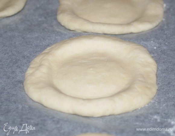 Когда тесто подошло второй раз (еще полчаса после того, как обмяли), сформировать из него шарики. Шарики раскатать скалкой немного, накрыть влажной салфеткой и оставить на 15-20 минут в теплом месте. Потом стаканом с плоским дном сделать в лепешке углубление. Часть ватрушек я сделала круглыми, часть фигурными.