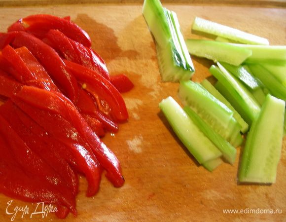 Перцы обсушиваем от масла и нарезаем полосочками. Авокадо разделяем напополам, достаем косточку, очищаем от кожуры, нарезаем ломтиками и сбрызгиваем лимонным соком (у меня на фото не авокадо, а огурец, так как случился казус: авокадо был забыт на кассе при оплате и пришлось срочно искать ему замену).
